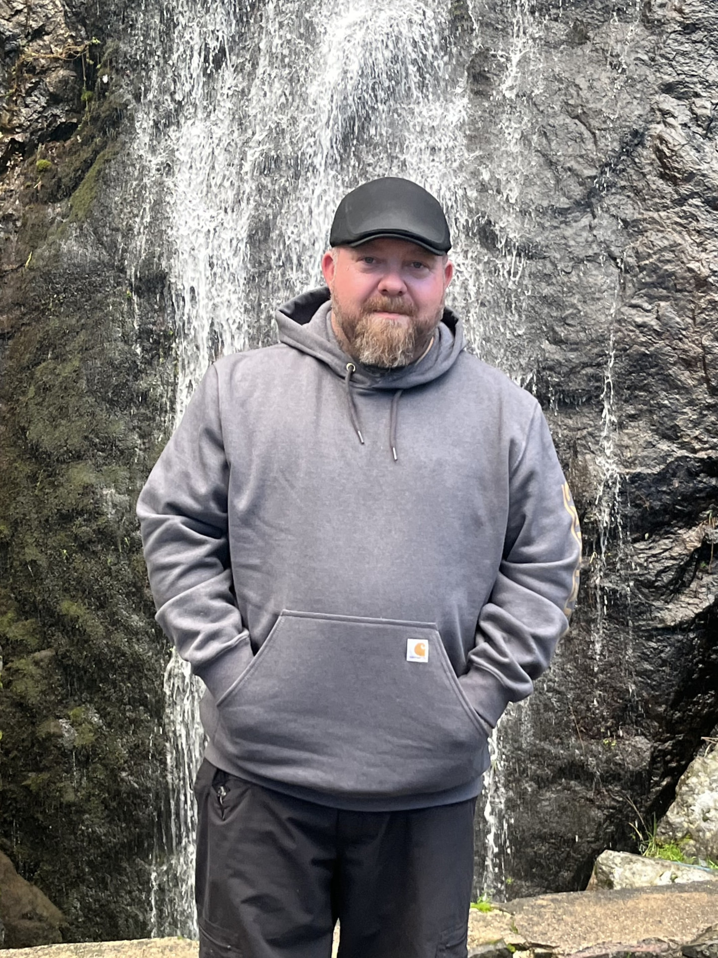 Veterans Take Charge team member standing in front of a waterfall